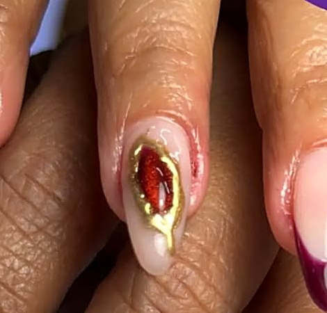 Burgundy French nails with a red gem design at Uvabon Nail Salon